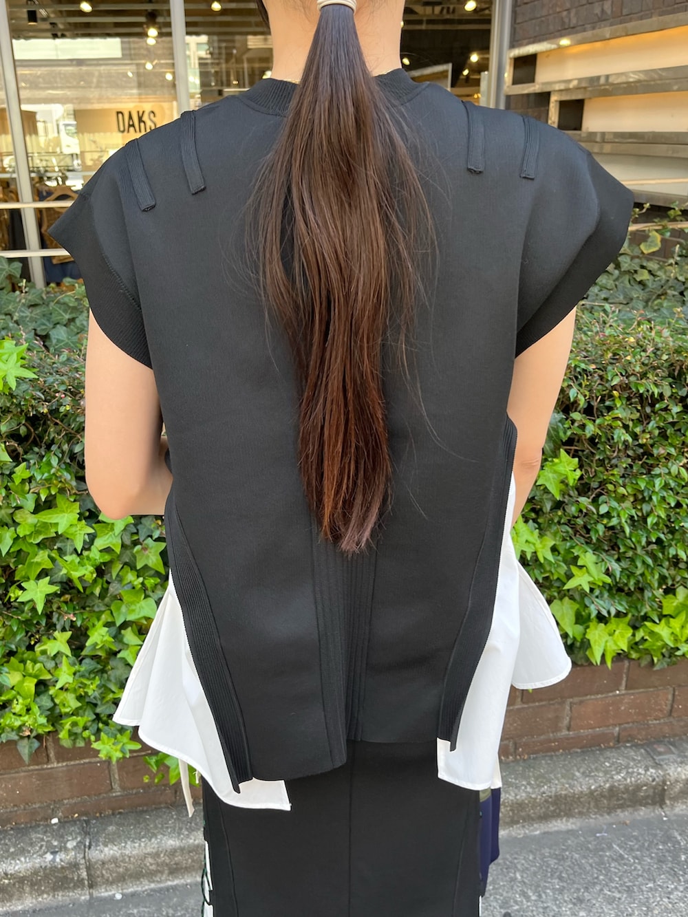 ブラック系のニット/セーター、ブラック系のスカート、その他のサンダルを着用したレディースの春コーディネートの8枚目の写真