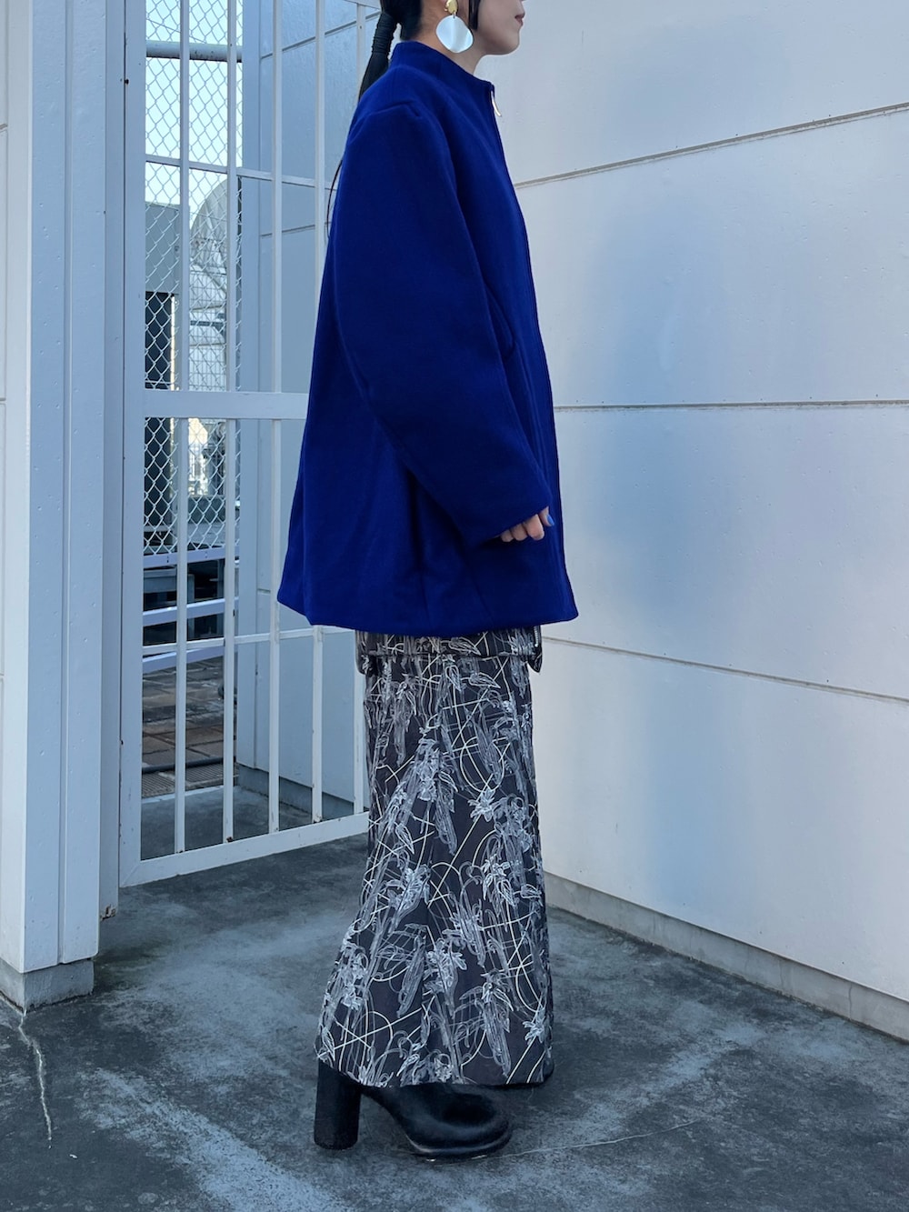 ブルー系のその他アウター、ブラック系のスカート、ブラック系のブーツを着用したレディースの冬コーディネートの3枚目の写真