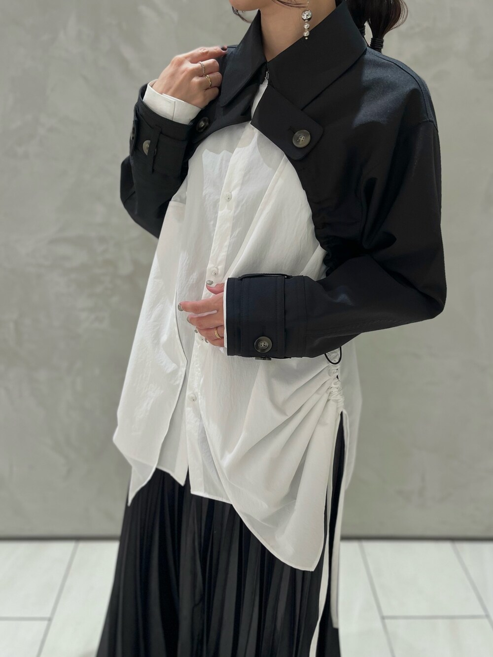 ブラック系のスカート、ホワイト系のシャツ/ブラウス、ブラック系のブルゾンを着用したレディースの秋コーディネートの4枚目の写真