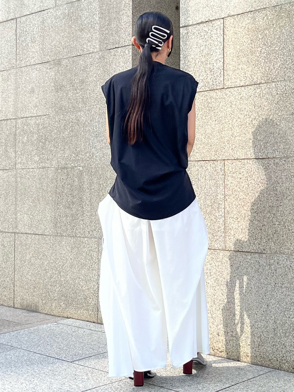 イエロー系のトートバッグ、ブラック系のTシャツ/カットソー、ホワイト系のその他パンツを着用したレディースの春コーディネートの2枚目の写真