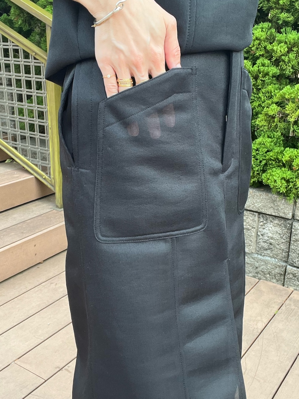 ブラック系のTシャツ/カットソー、ブラック系のスカート、ブラック系のサンダルを着用したレディースの春コーディネートの6枚目の写真