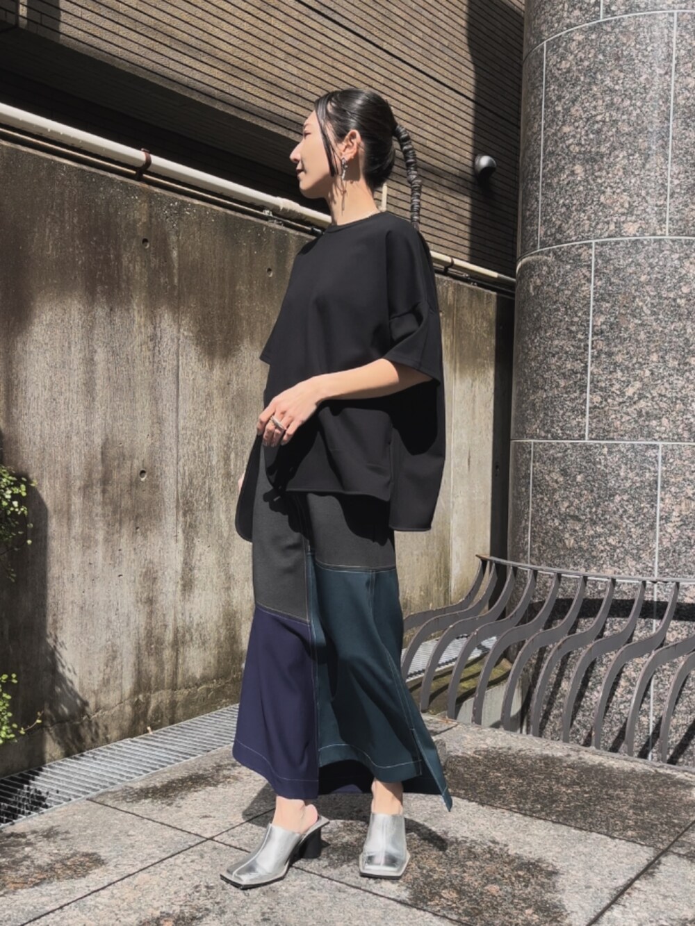 ブラック系のTシャツ/カットソー、グリーン系のスカート、シルバー系のパンプスを着用したレディースの春コーディネートの2枚目の写真