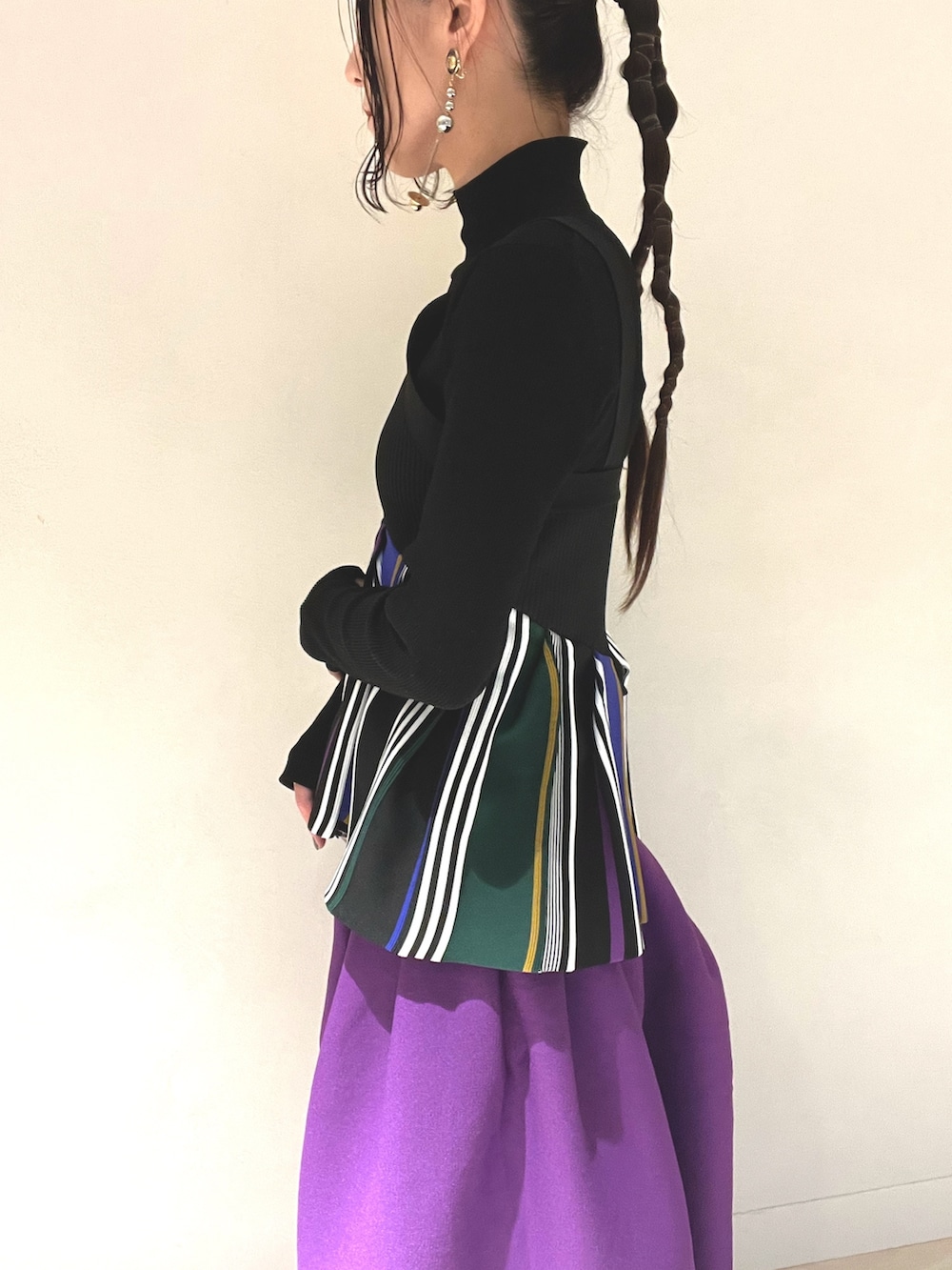 ブラック系のキャミソール、パープル系のスカート、ブラック系のブーツを着用したレディースの冬コーディネートの5枚目の写真