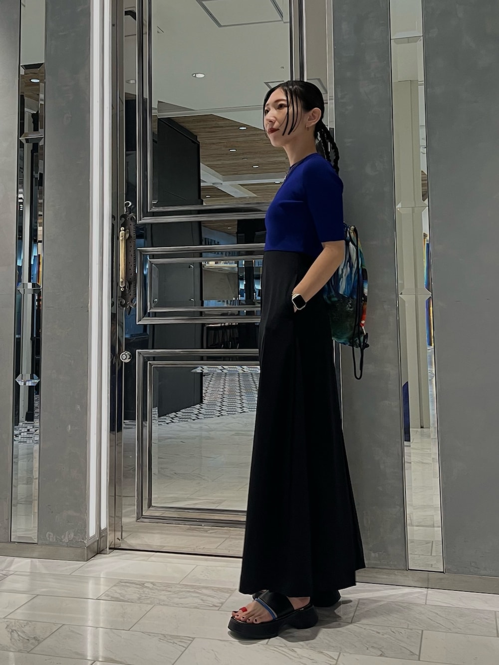 ブラック系のワンピース、ブルー系のニット/セーター、その他のサンダルを着用したレディースの春コーディネートの4枚目の写真