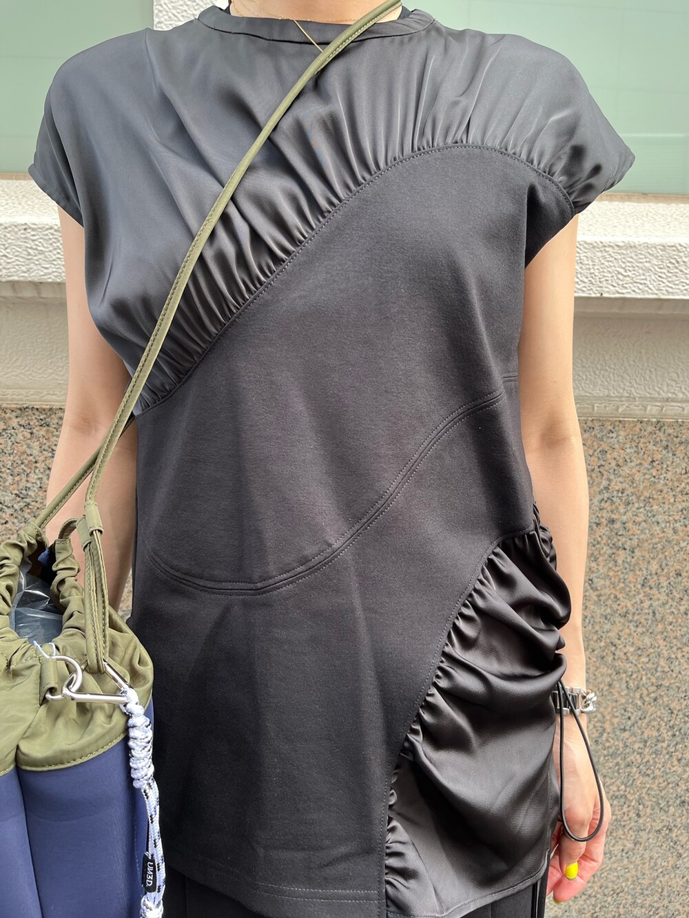 ブラック系のTシャツ/カットソー、ブラック系のその他パンツ、グリーン系のショルダーバッグを着用したレディースの夏コーディネートの3枚目の写真