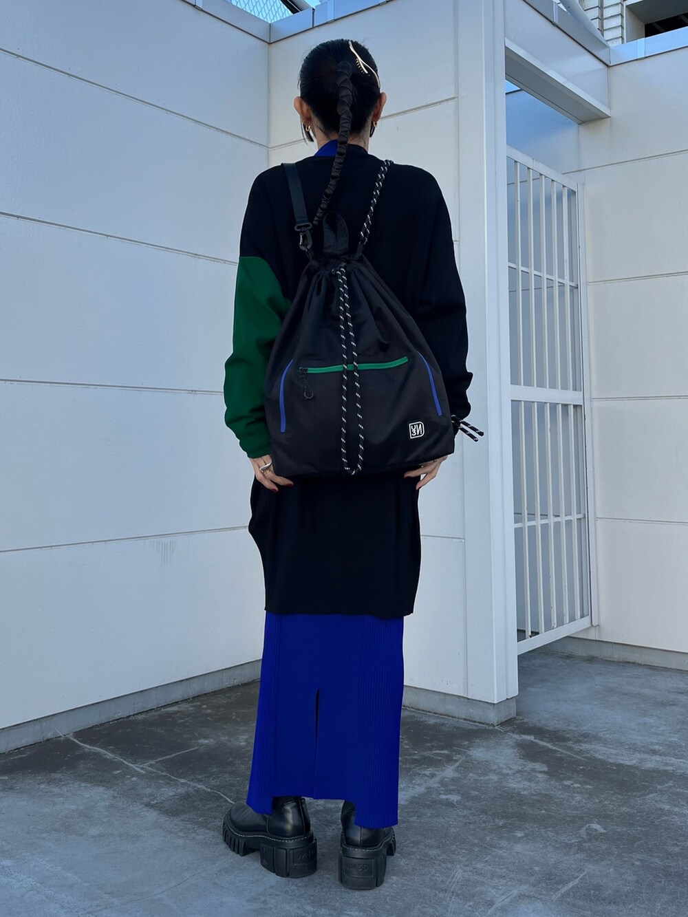 ブラック系のニット/セーター、ブラック系のカーディガン/ボレロ、ブルー系のスカートを着用したレディースの冬コーディネートの3枚目の写真