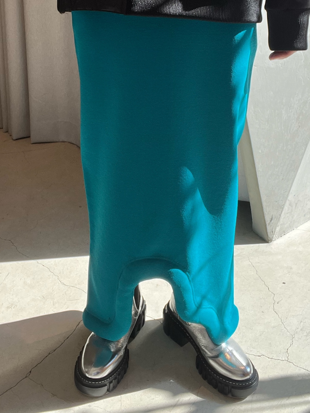 ブラック系のスウェット、ブルー系のスカート、ブラック系のブーツを着用したレディースの冬コーディネートの6枚目の写真