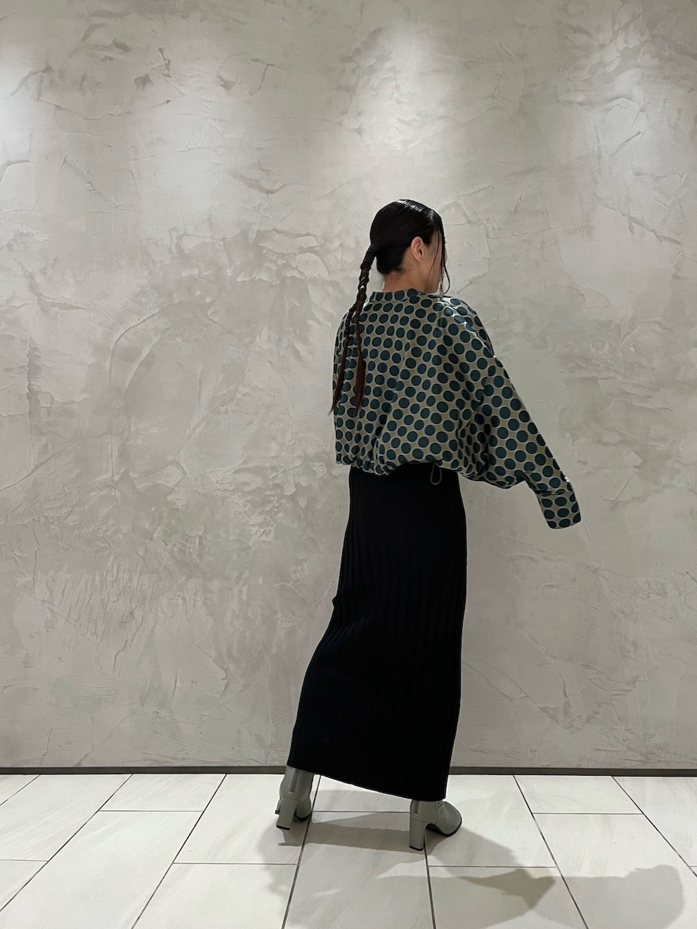 グリーン系のブルゾン、ブラック系のワンピース、ベージュ系のブーツを着用したレディースの冬コーディネートの3枚目の写真