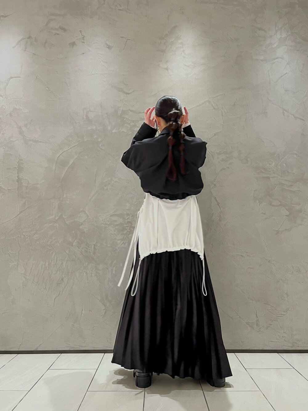 ブラック系のスカート、ホワイト系のシャツ/ブラウス、ブラック系のブルゾンを着用したレディースの秋コーディネートの3枚目の写真