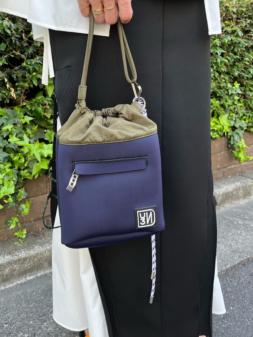 ブラック系のニット/セーター、ブラック系のスカート、その他のサンダルを着用したレディースの春コーディネートの7枚目の写真