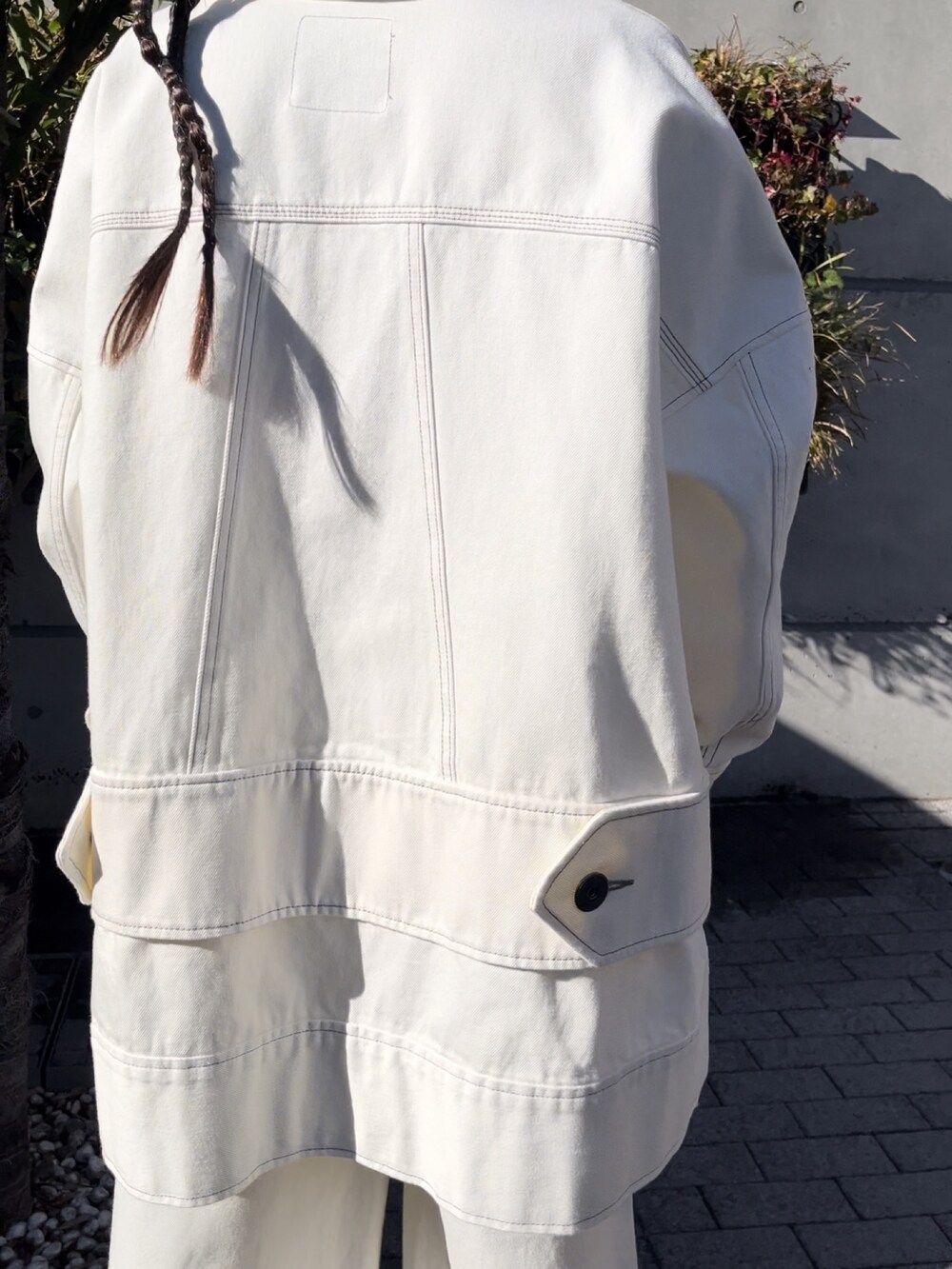 ホワイト系のデニムジャケット、ホワイト系のデニムパンツ、ブラック系のブーツを着用したレディースの冬コーディネートの7枚目の写真