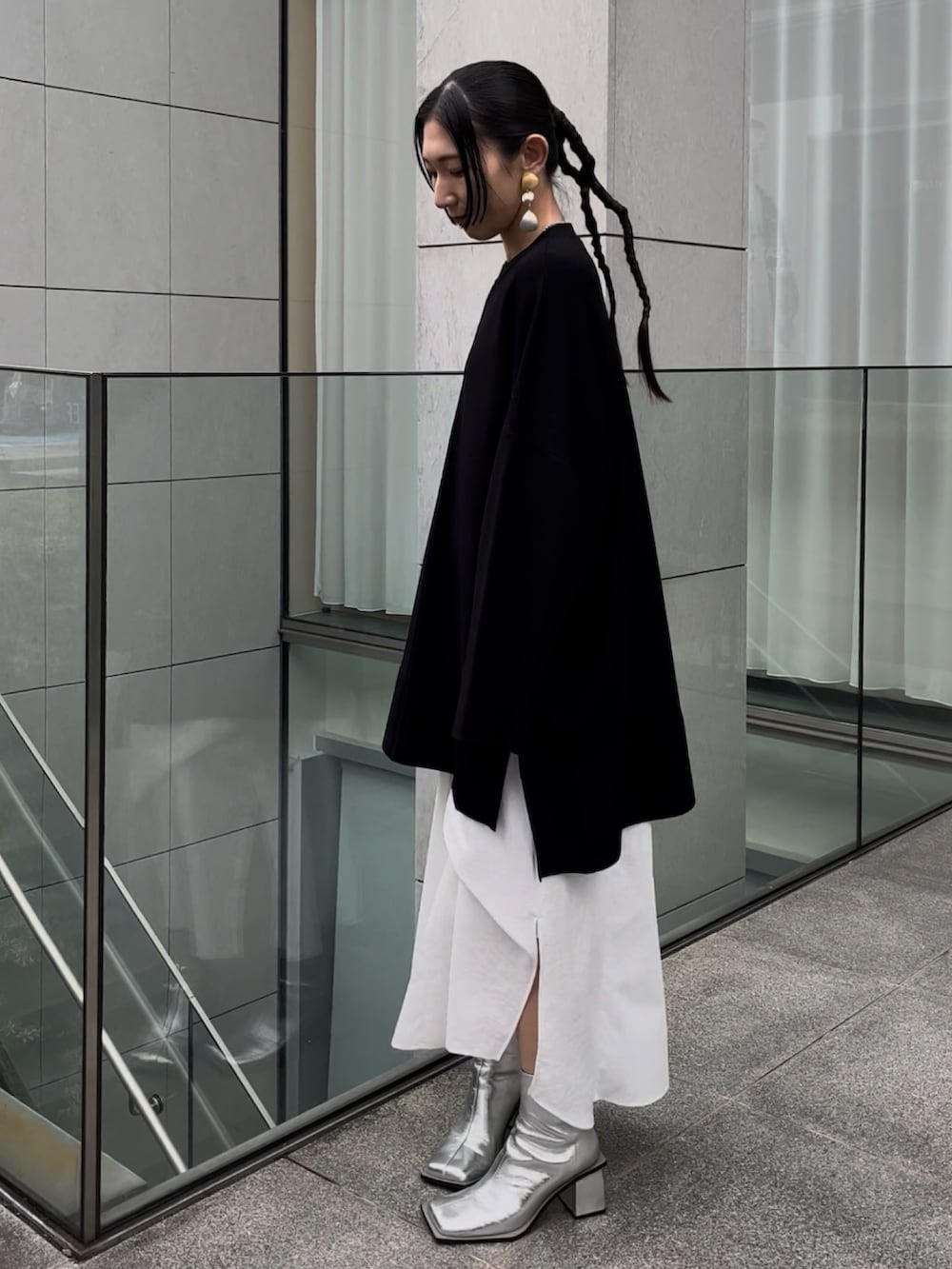 ブラック系のニット/セーター、ホワイト系のワンピース、シルバー系のブーツを着用したレディースの冬コーディネートの2枚目の写真