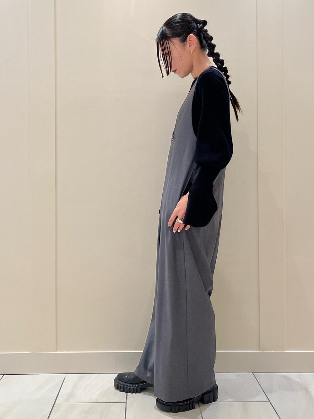 グレー系のつなぎ/オールインワン、ブラック系のニット/セーター、ブラック系のブーツを着用したレディースの冬コーディネートの2枚目の写真