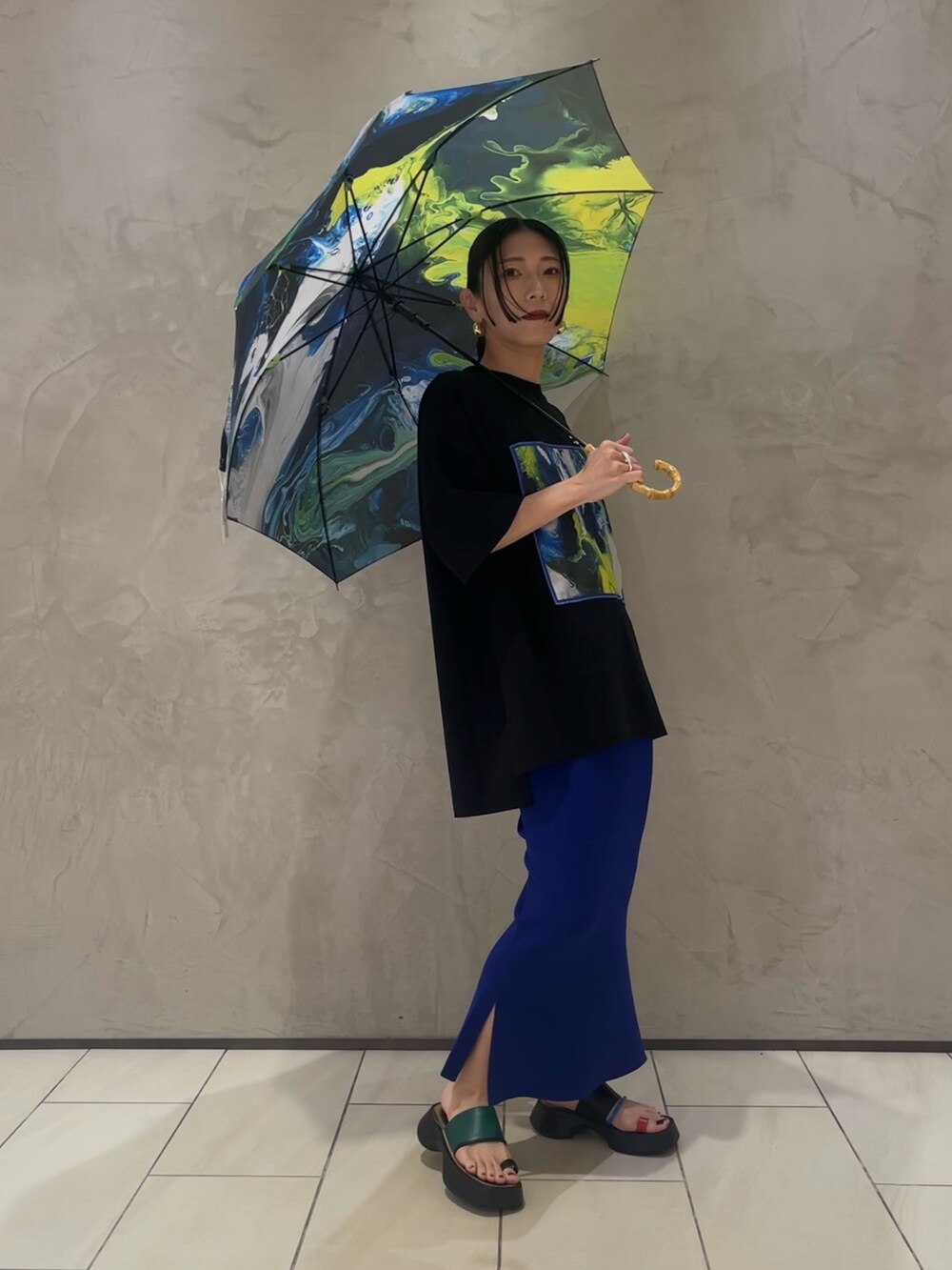 ブラック系のTシャツ/カットソー、ブルー系のスカート、その他のサンダルを着用したレディースの夏コーディネートの2枚目の写真