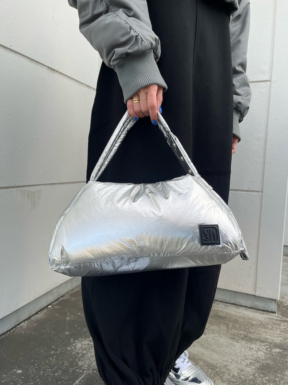 ブラック系のワンピース、グレー系のMA-1、シルバー系のハンドバッグを着用したレディースの冬コーディネートの8枚目の写真