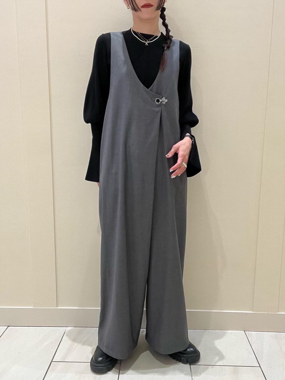 グレー系のつなぎ/オールインワン、ブラック系のニット/セーター、ブラック系のブーツを着用したレディースの冬コーディネートの3枚目の写真