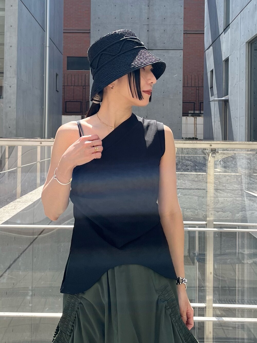 ブラック系のTシャツ/カットソー、グリーン系のスカート、ブラック系のサンダルを着用したレディースの春コーディネートの4枚目の写真