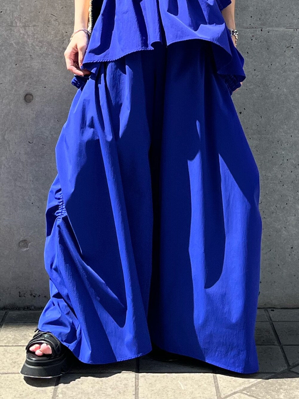 ブルー系のタンクトップ、ブルー系のその他パンツ、ブラック系のサンダルを着用したレディースの夏コーディネートの6枚目の写真