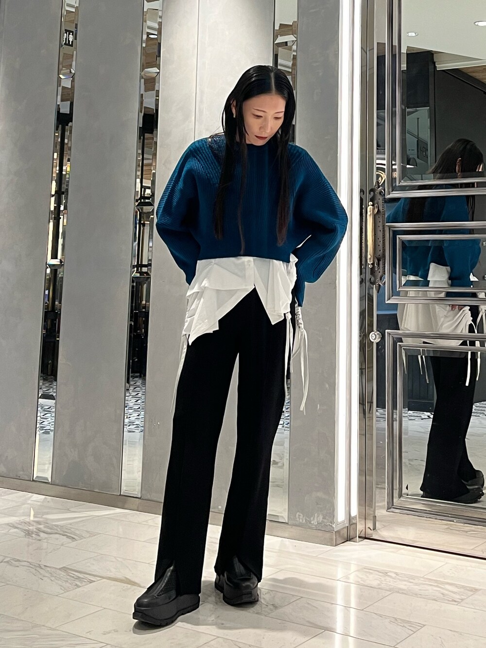 ブラック系のその他パンツ、ホワイト系のキャミソール、ブルー系のニット/セーターを着用したレディースの冬コーディネートの2枚目の写真