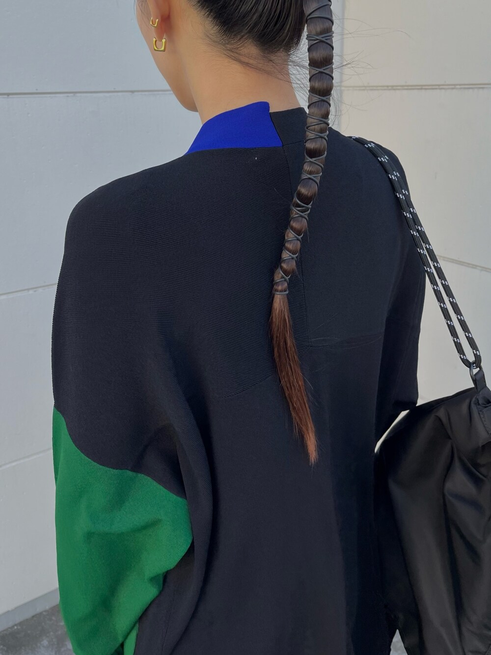 ブラック系のニット/セーター、ブラック系のカーディガン/ボレロ、ブルー系のスカートを着用したレディースの冬コーディネートの6枚目の写真