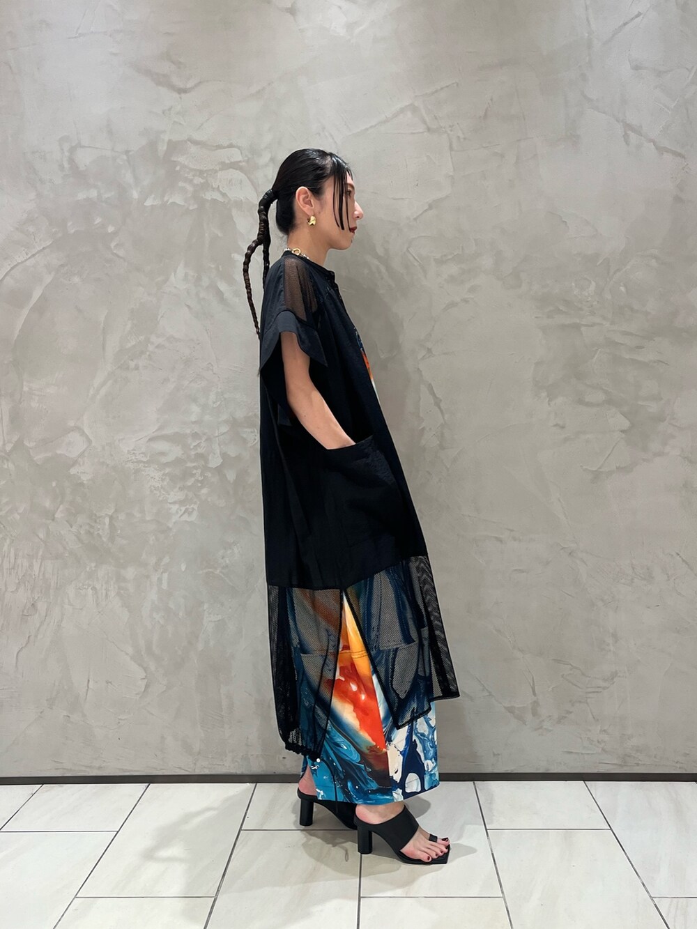 オレンジ系のワンピース、ブラック系のシャツ/ブラウス、ブラック系のサンダルを着用したレディースの春コーディネートの4枚目の写真