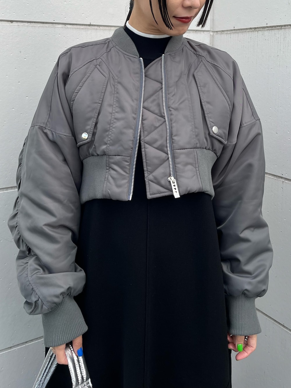 ブラック系のワンピース、グレー系のMA-1、シルバー系のハンドバッグを着用したレディースの冬コーディネートの4枚目の写真