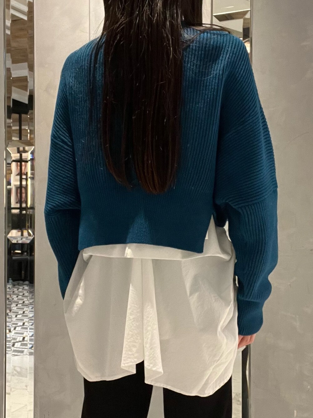 ブラック系のその他パンツ、ホワイト系のキャミソール、ブルー系のニット/セーターを着用したレディースの冬コーディネートの5枚目の写真