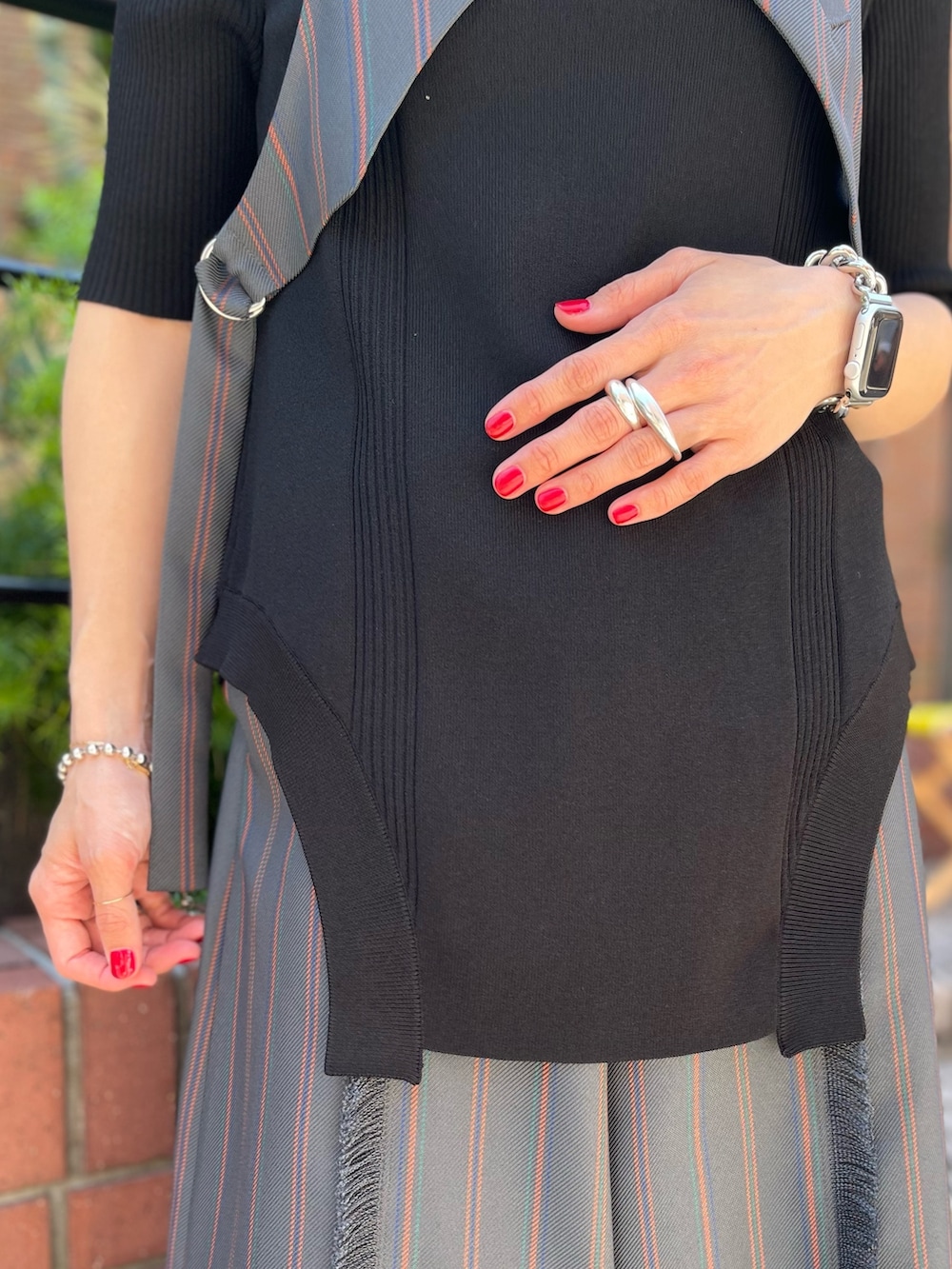 グレー系のスラックス、ブラック系のパンプス、ブラック系のニット/セーターを着用したレディースの春コーディネートの4枚目の写真