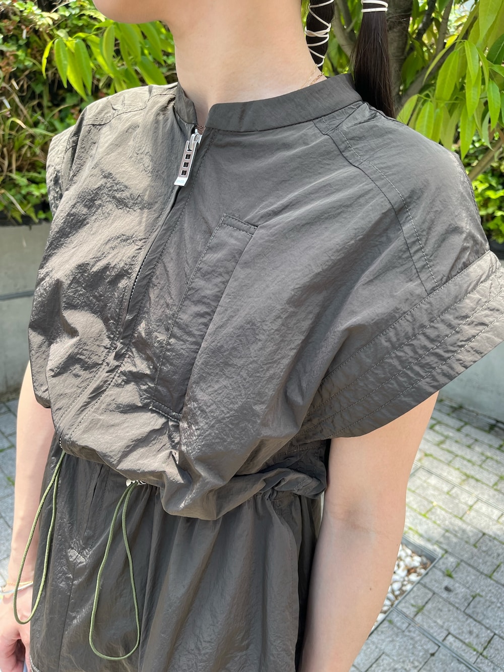 グリーン系のワンピース、ブラック系のサンダル、グレー系のショルダーバッグを着用したレディースの夏コーディネートの5枚目の写真