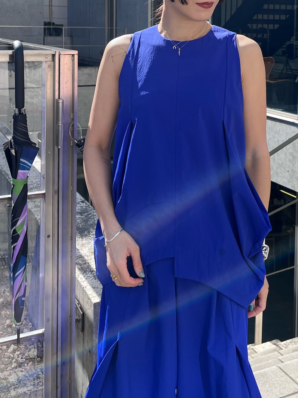 ブルー系のタンクトップ、ブルー系のその他パンツ、ブラック系の長傘を着用したレディースの春コーディネートの3枚目の写真