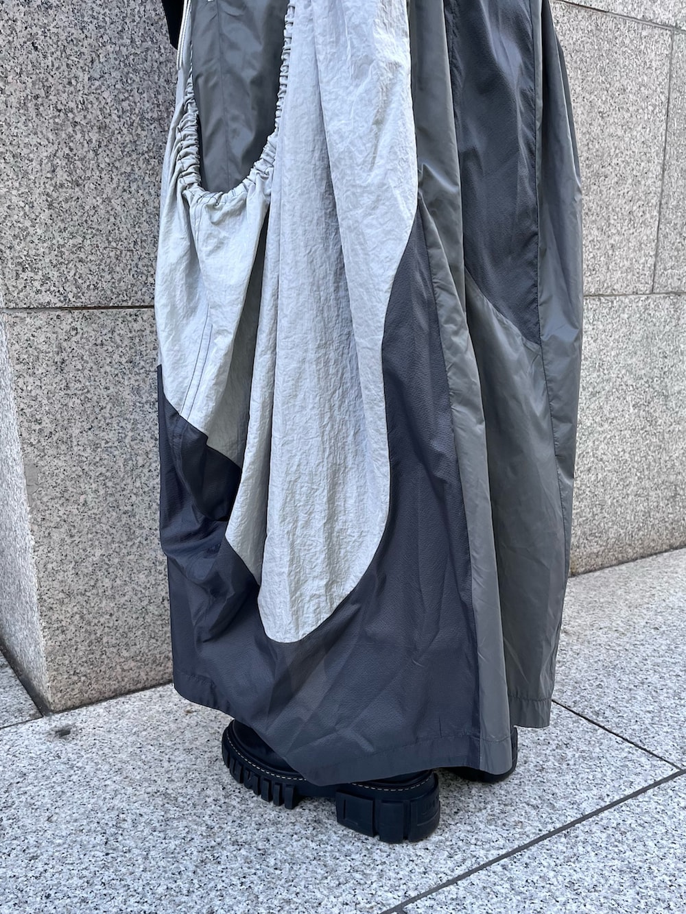 ブラック系のブルゾン、グレー系のタンクトップ、グレー系のジャンパースカートを着用したレディースの春コーディネートの8枚目の写真