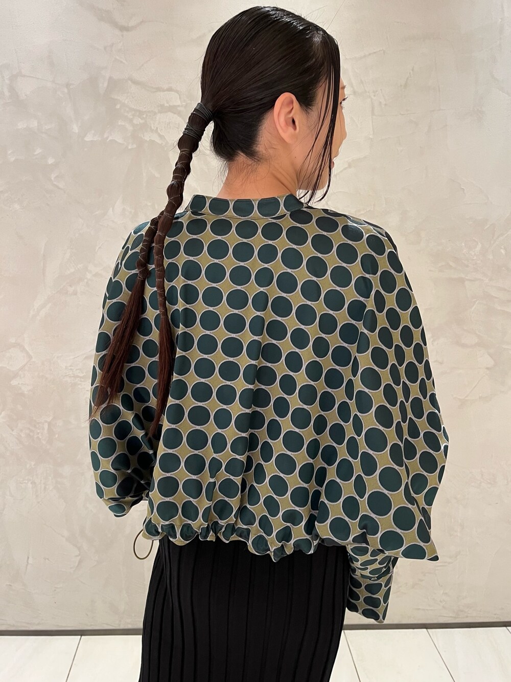 グリーン系のブルゾン、ブラック系のワンピース、ベージュ系のブーツを着用したレディースの冬コーディネートの5枚目の写真