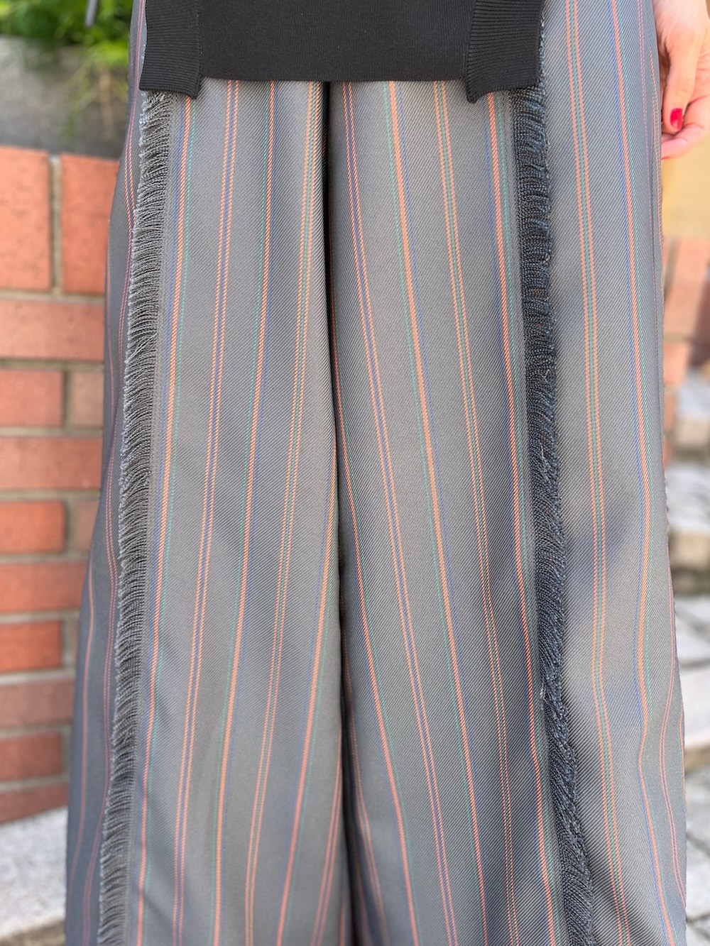 グレー系のスラックス、ブラック系のパンプス、ブラック系のニット/セーターを着用したレディースの春コーディネートの5枚目の写真