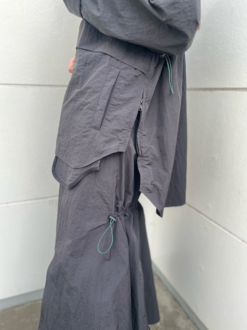 ブラック系のマウンテンパーカー、ブラック系のスカートを着用したレディースの夏コーディネートの8枚目の写真