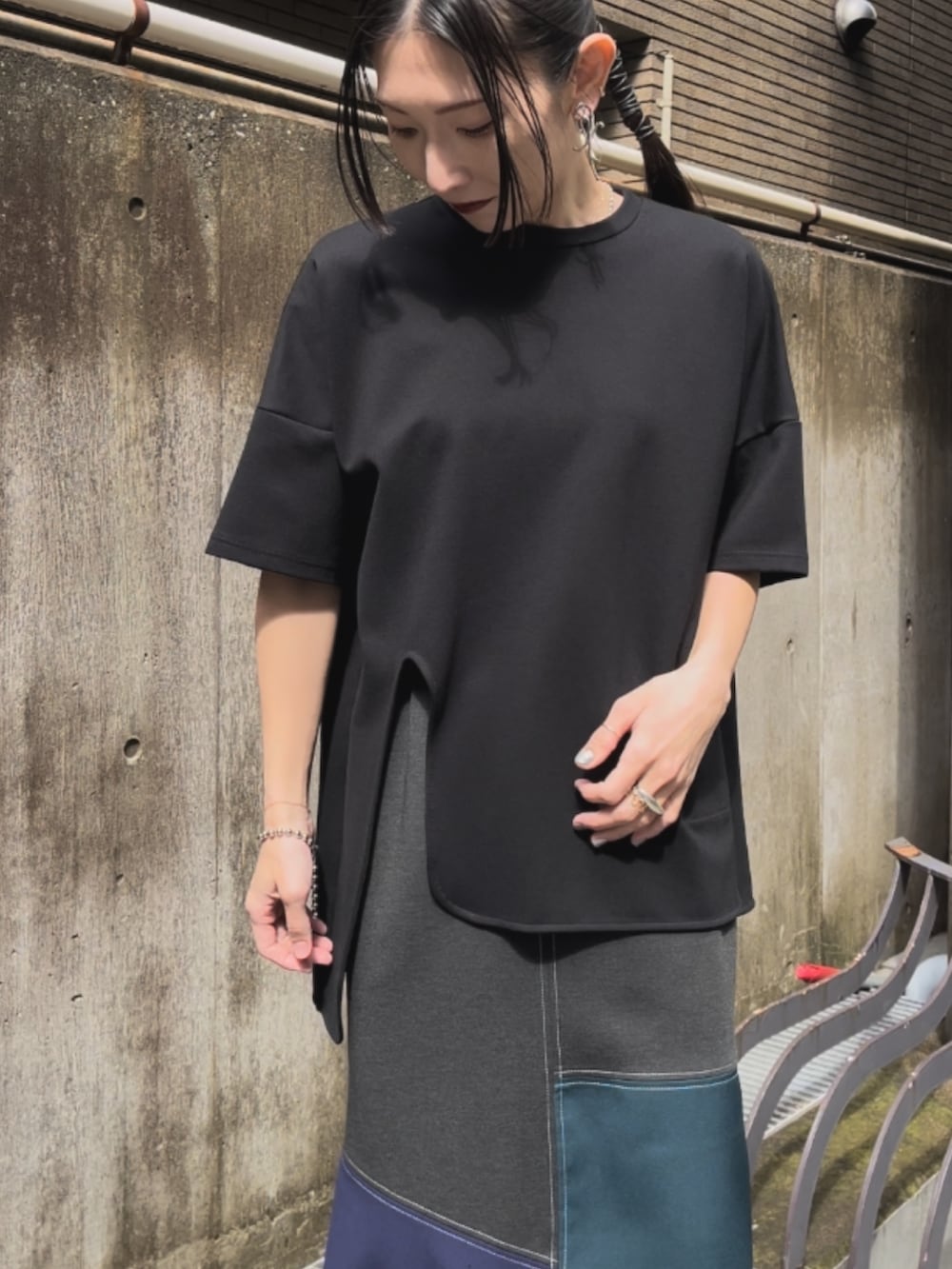 ブラック系のTシャツ/カットソー、グリーン系のスカート、シルバー系のパンプスを着用したレディースの春コーディネートの3枚目の写真