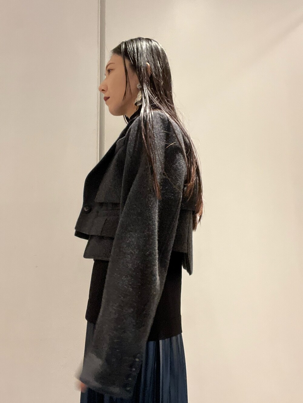 ブルー系のスカート、ブラック系のブーツ、その他のショルダーバッグを着用したレディースの秋コーディネートの4枚目の写真