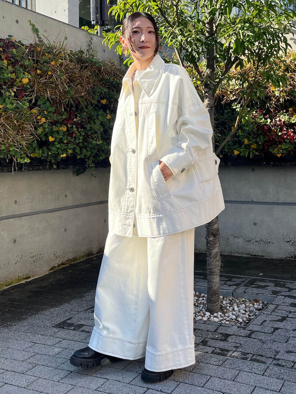 ホワイト系のデニムジャケット、ホワイト系のデニムパンツ、ブラック系のブーツを着用したレディースの冬コーディネートの2枚目の写真