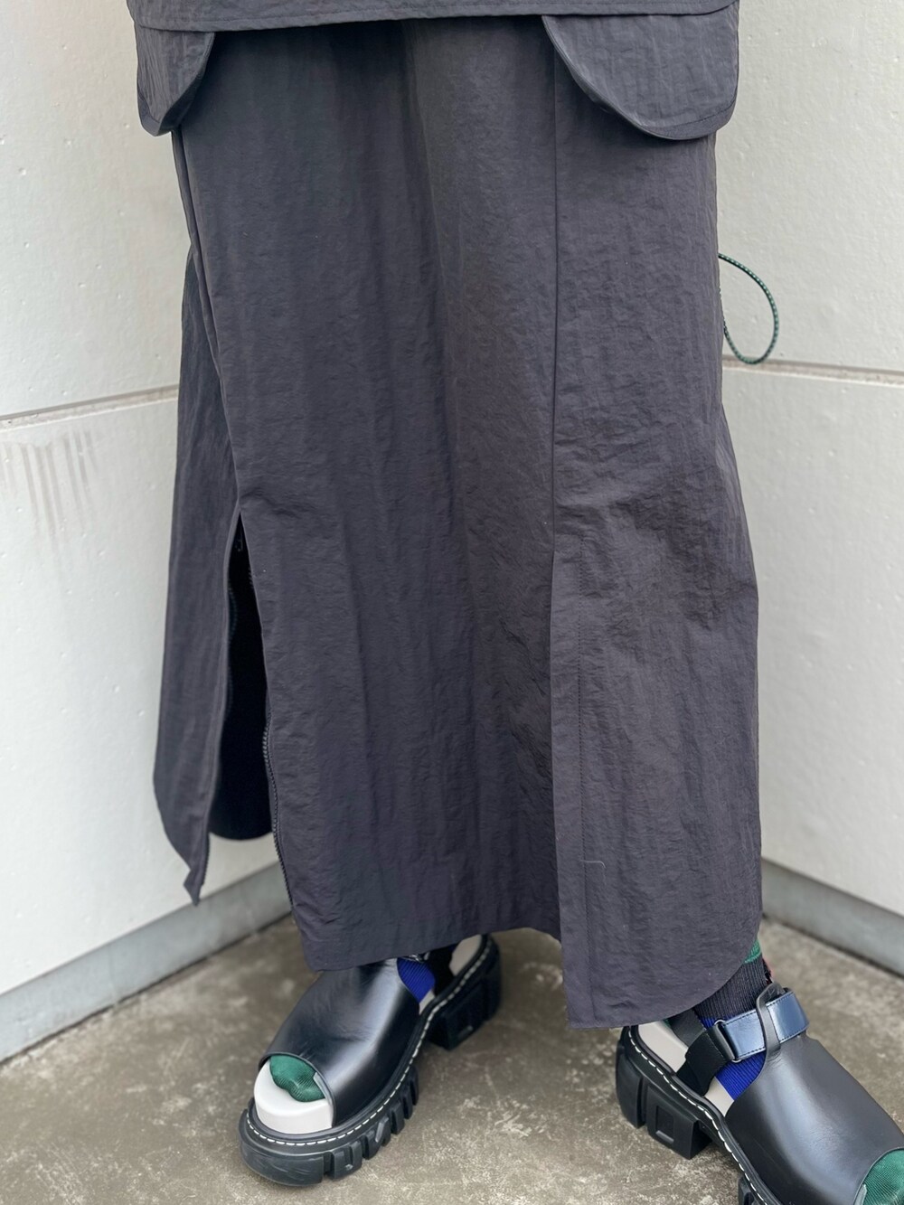 ブラック系のマウンテンパーカー、ブラック系のスカートを着用したレディースの夏コーディネートの7枚目の写真