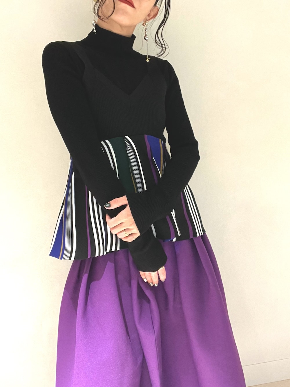 ブラック系のキャミソール、パープル系のスカート、ブラック系のブーツを着用したレディースの冬コーディネートの4枚目の写真