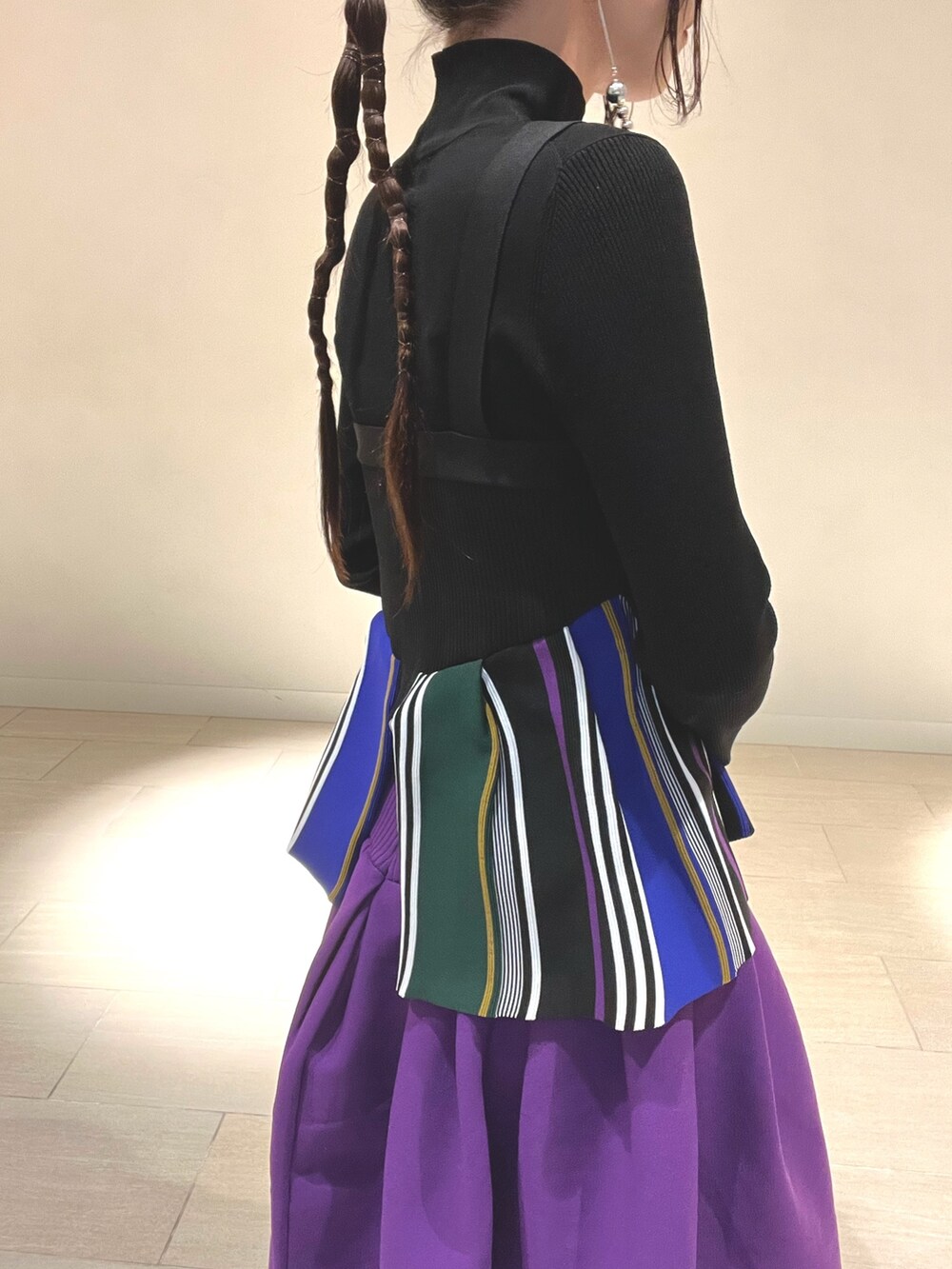 ブラック系のキャミソール、パープル系のスカート、ブラック系のブーツを着用したレディースの冬コーディネートの6枚目の写真