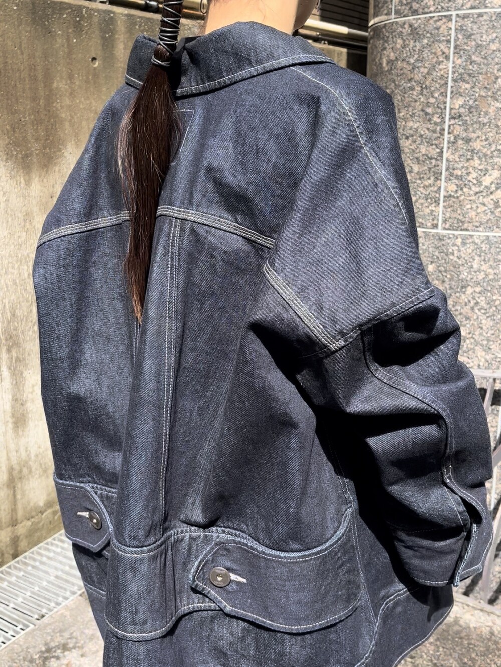 ブラック系のTシャツ/カットソー、ブルー系のデニムジャケット、グリーン系のスカートを着用したレディースの春コーディネートの4枚目の写真