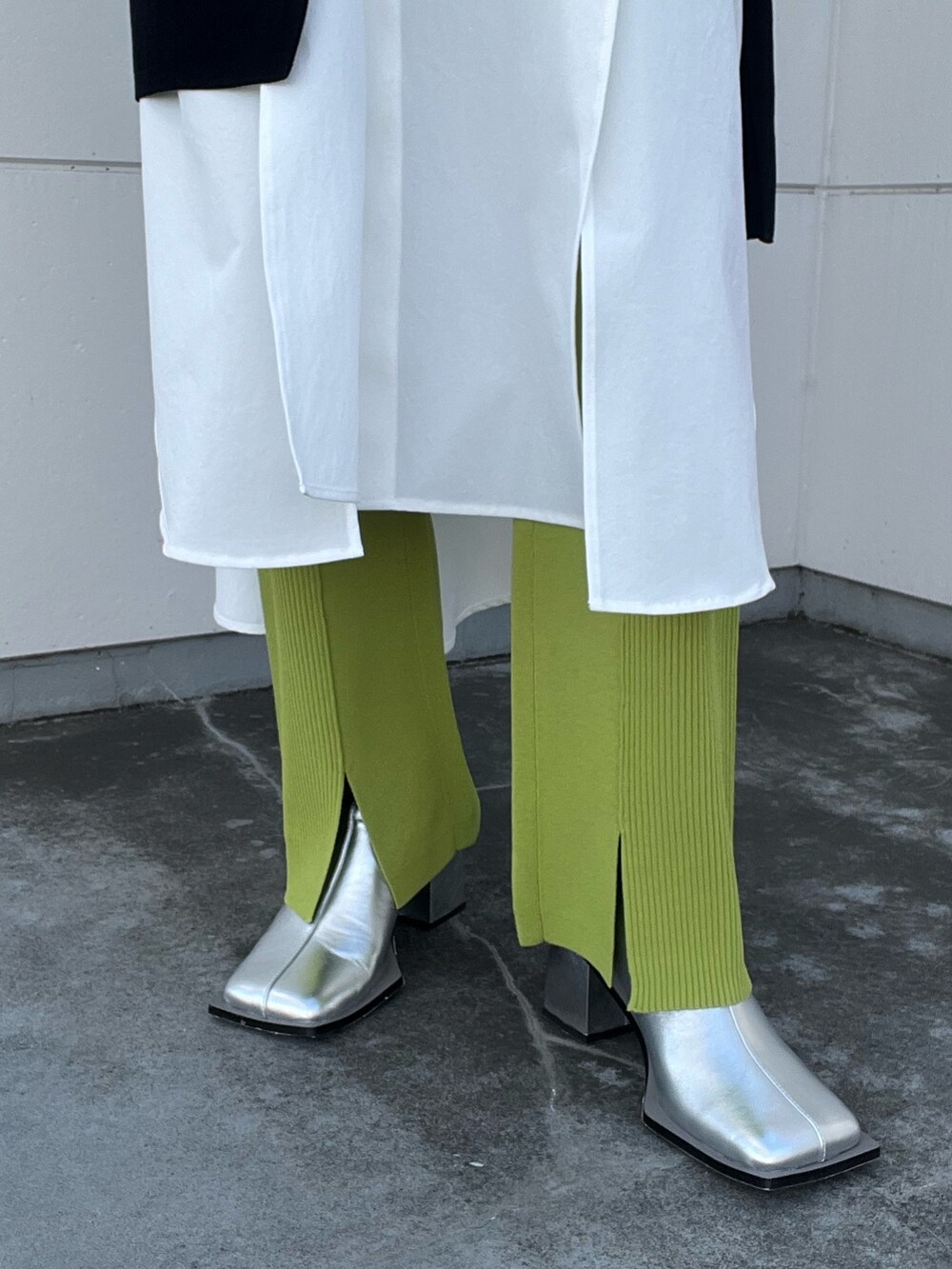 ブラック系のニット/セーター、ホワイト系のワンピース、グリーン系のその他パンツを着用したレディースの冬コーディネートの6枚目の写真