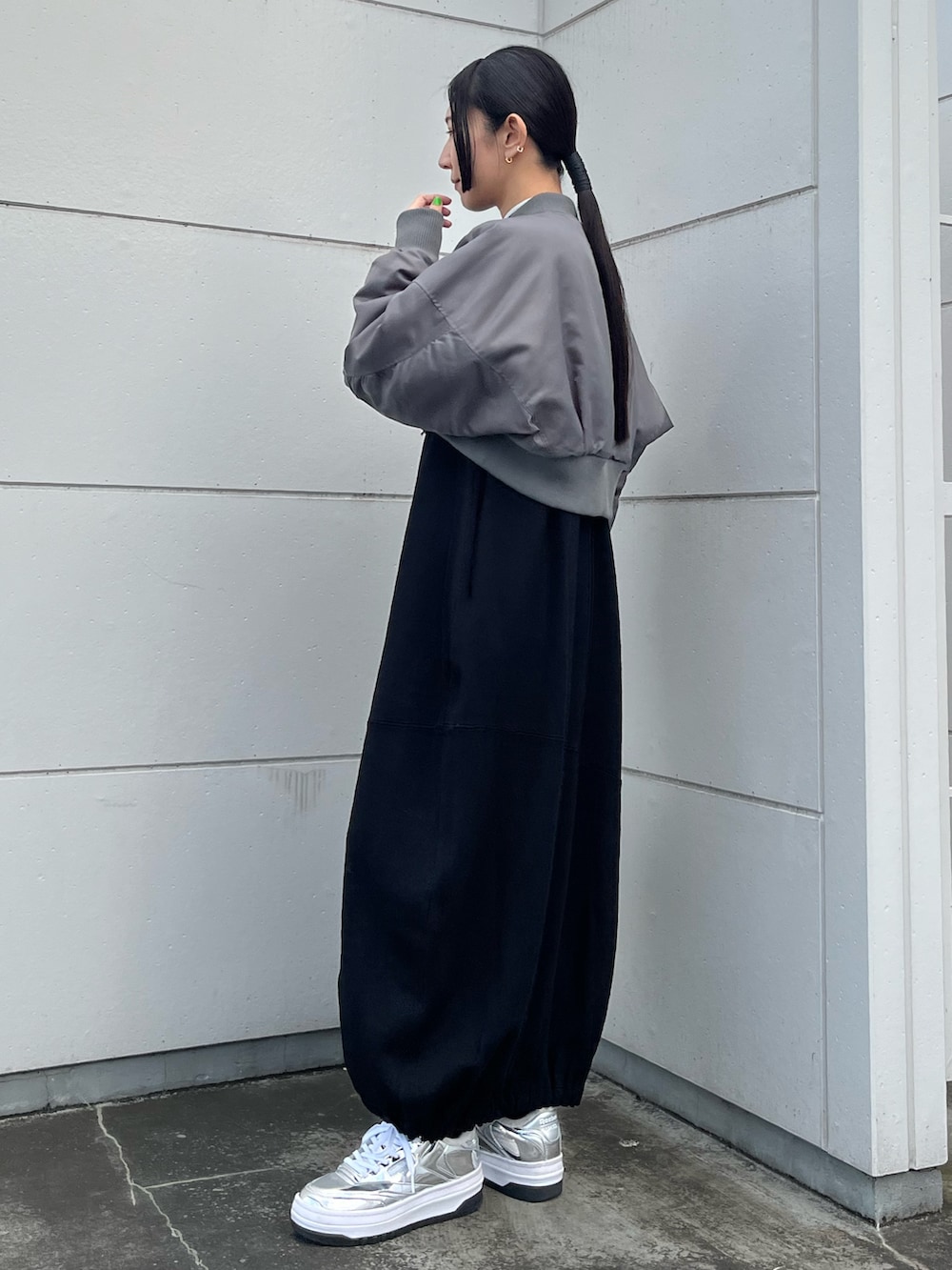 ブラック系のワンピース、グレー系のMA-1、シルバー系のハンドバッグを着用したレディースの冬コーディネートの3枚目の写真