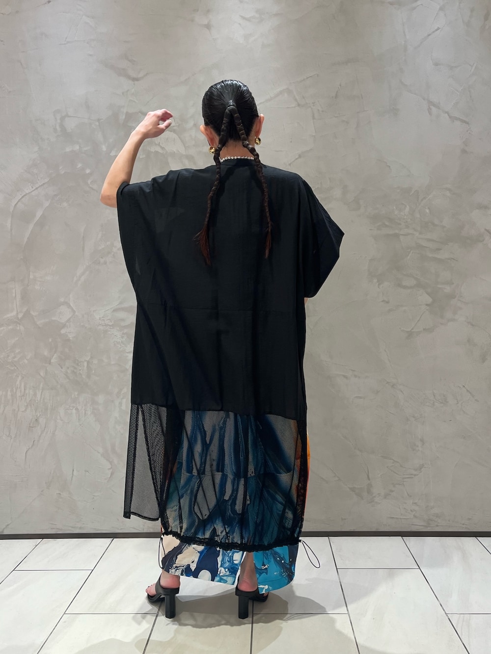 オレンジ系のワンピース、ブラック系のシャツ/ブラウス、ブラック系のサンダルを着用したレディースの春コーディネートの5枚目の写真