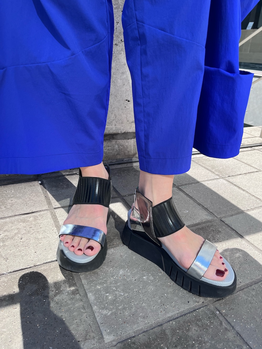 ブルー系のタンクトップ、ブルー系のその他パンツ、ブラック系の長傘を着用したレディースの春コーディネートの7枚目の写真