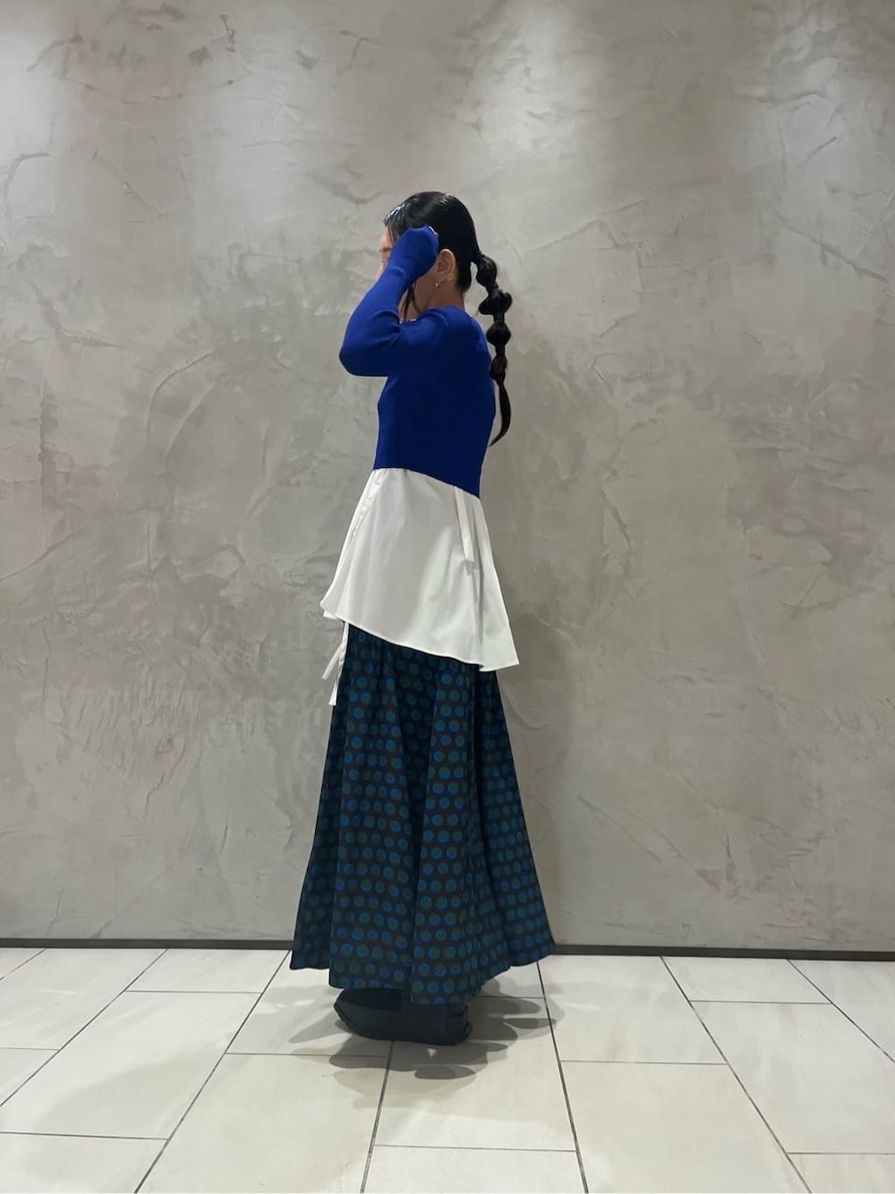 ホワイト系のキャミソール、ブラック系のスカート、ブルー系のニット/セーターを着用したレディースの秋コーディネートの2枚目の写真