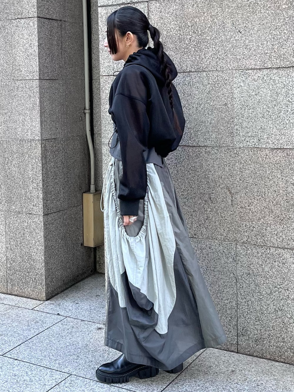 ブラック系のブルゾン、グレー系のタンクトップ、グレー系のジャンパースカートを着用したレディースの春コーディネートの3枚目の写真