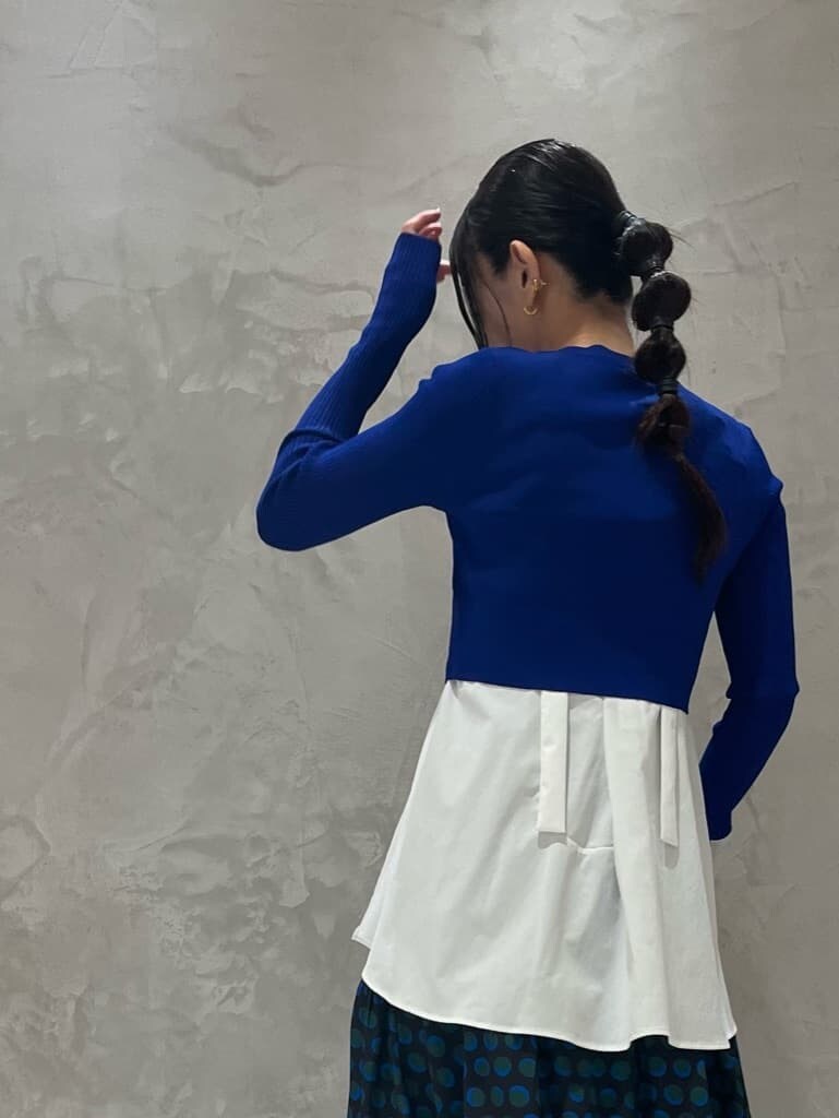 ホワイト系のキャミソール、ブラック系のスカート、ブルー系のニット/セーターを着用したレディースの秋コーディネートの4枚目の写真