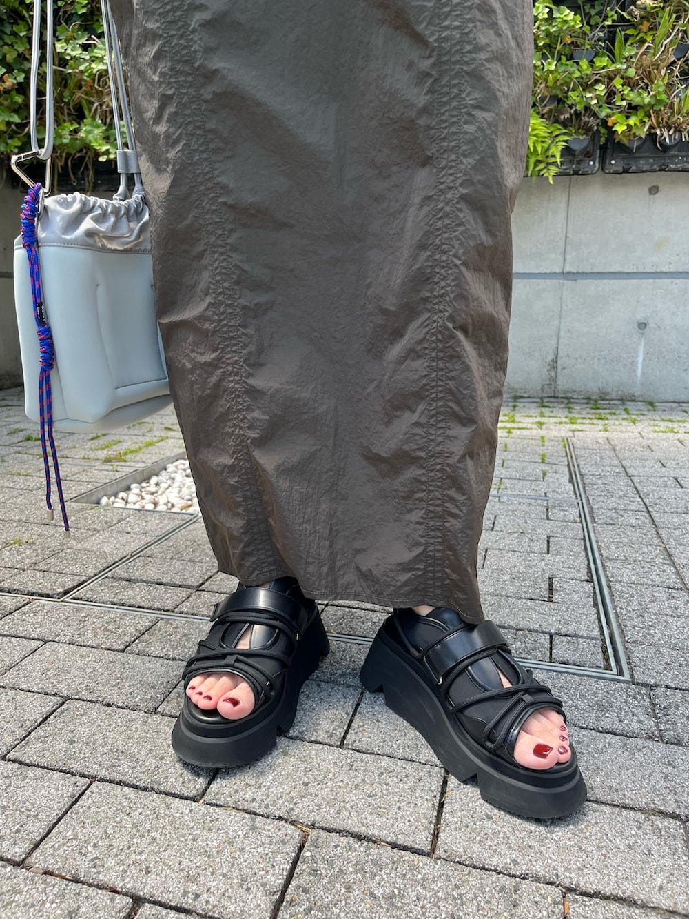 グリーン系のワンピース、ブラック系のサンダル、グレー系のショルダーバッグを着用したレディースの夏コーディネートの7枚目の写真