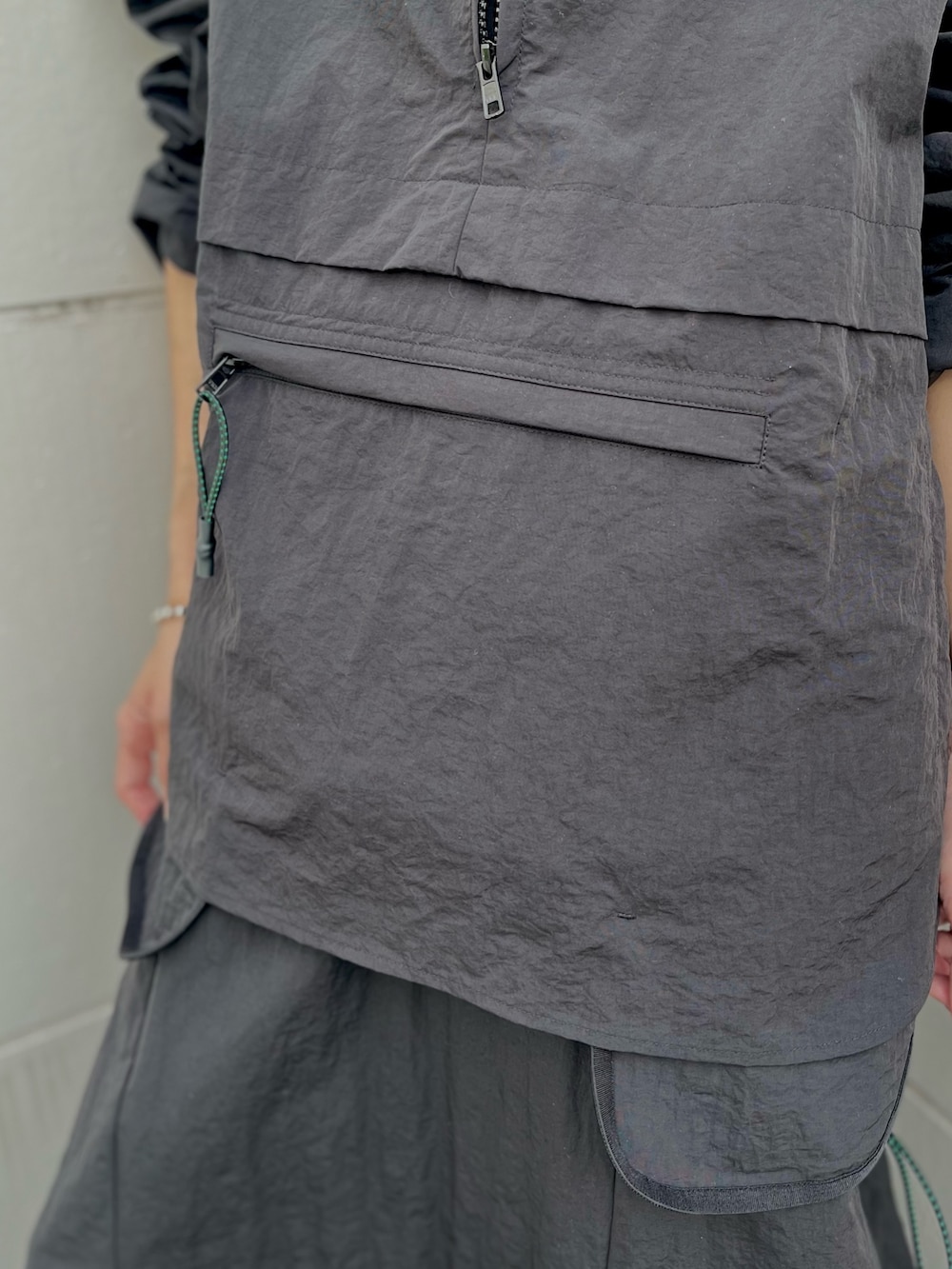 ブラック系のマウンテンパーカー、ブラック系のスカートを着用したレディースの夏コーディネートの6枚目の写真